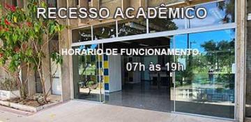 Horário de funcionamento recesso acadêmico 2022. Imagem da porta de entrada da biblioteca com o texto "recesso acadêmico, horário de funcionamento 7h as 19h, escritos em letra branca.